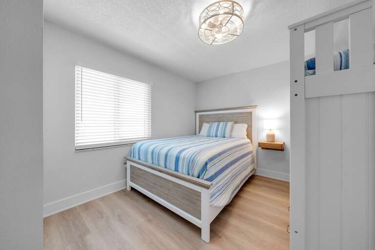 Plenty of space in the guest bedroom with a queen bed and a twin bunk bed