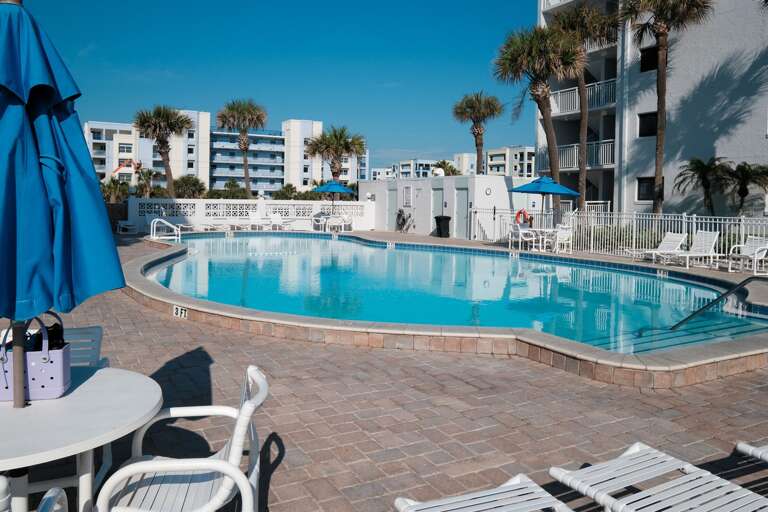 Convenient poolside bathrooms, along with tables and chairs on the Shorehom by the Sea pool deck, offer the ideal setup for ultimate comfort during your beachside retreat