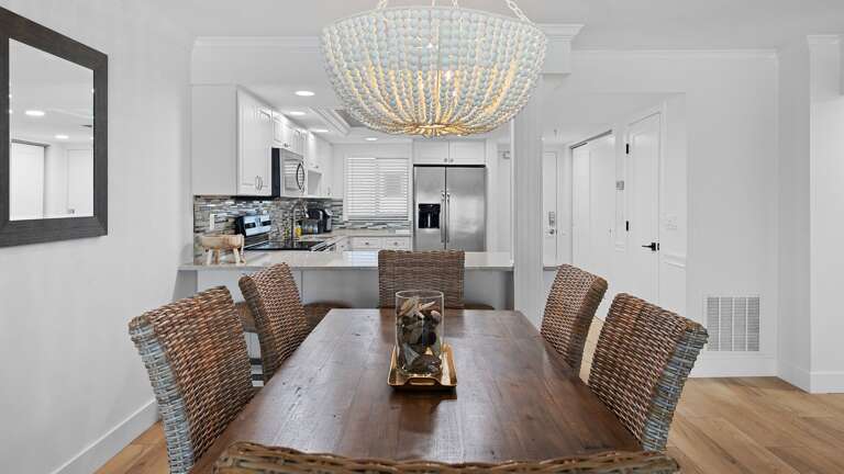 The dining room features seating for 6, providing the perfect space for family meals or gathering with friends while taking in the coastal atmosphere