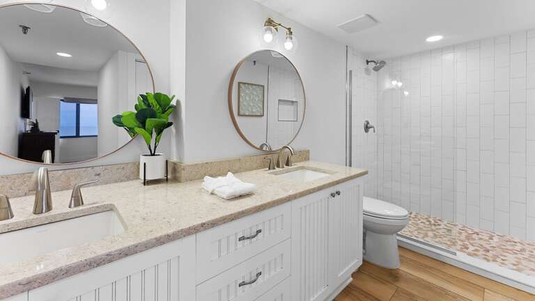 Experience a spa-like retreat in the master bathroom, complete with a double vanity and an updated glass and tile shower