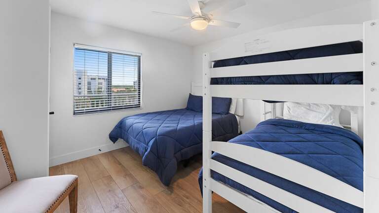 The guest bedroom features a cozy queen bed alongside a twin bunk bed, making it the perfect setup for families or groups