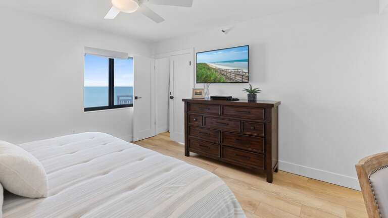 The oceanfront master bedroom suite features a king bed, a TV for your entertainment, and a private ensuite bathroom, creating the ultimate retreat for comfort and relaxation
