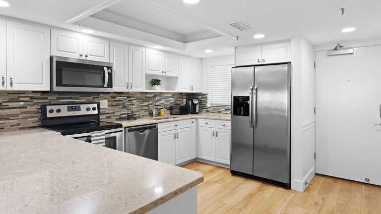 Prepare meals with ease in the fully-equipped kitchen, featuring sleek stainless steel appliances