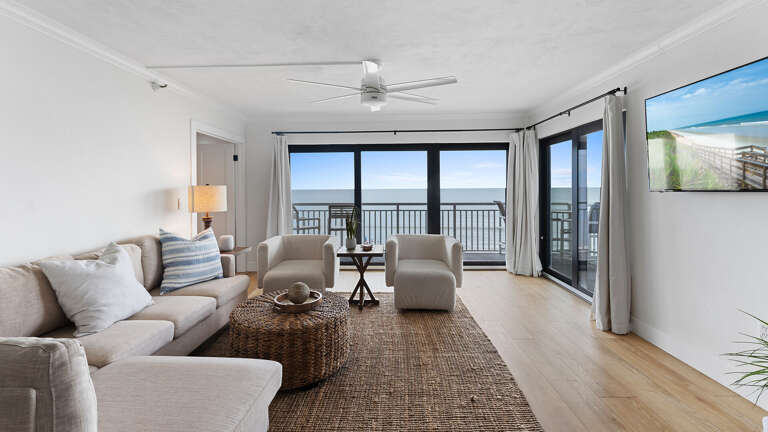 Relax in the oceanfront living room, offering panoramic views of New Smyrna Beach's white sands