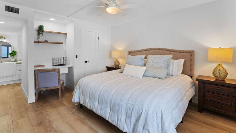 Relax in the spacious master bedroom suite, featuring a comfortable king bed and a dedicated workspace with a desk and chair