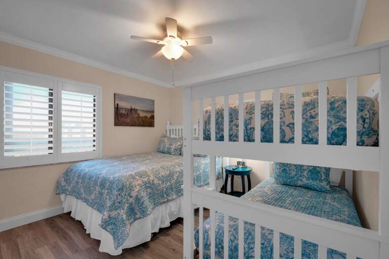 The guest bedroom has a queen bed, twin bunk bed, and fresh linens