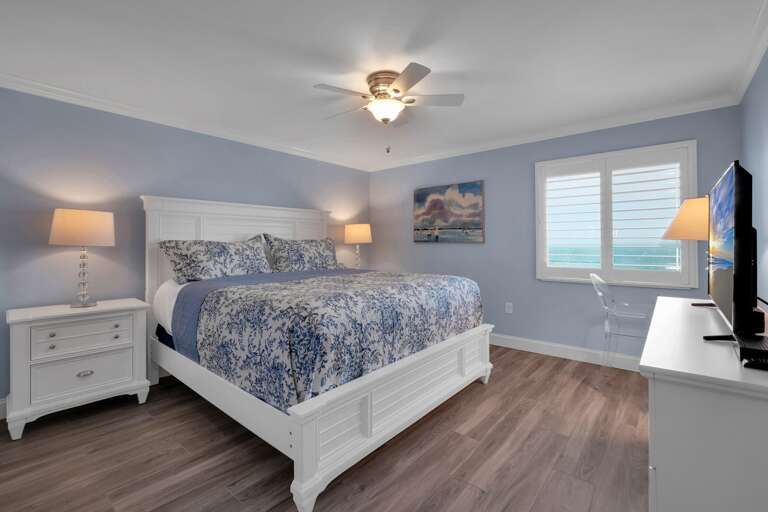 The oceanfront master bedroom suite features a comfortable king bed, a large TV, and a stunning Atlantic Ocean view