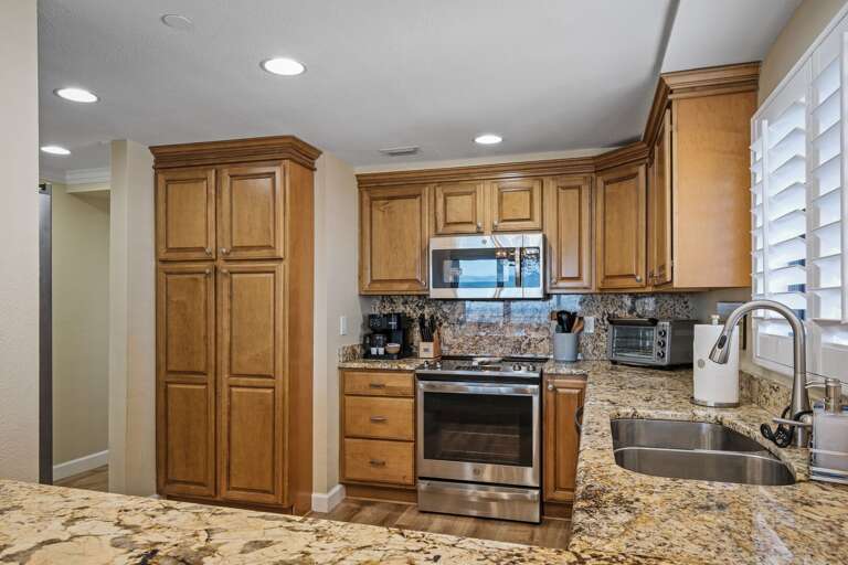 Cook with ease in the fully equipped kitchen, featuring modern stainless steel appliances and plenty of space for meal prep in this oceanfront New Smyrna Beach condo