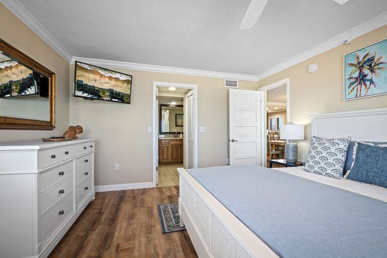 The master suite features a king bed, mounted TV, and a private ensuite bathroom