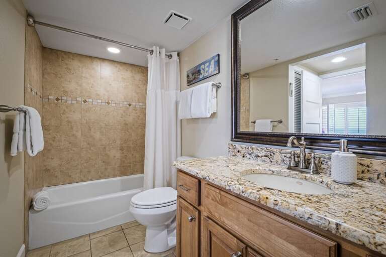 The updated master bathroom boasts a tub/shower combo and elegant granite countertops for a luxurious touch
