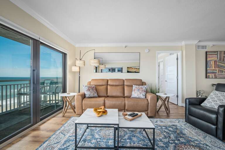 The updated oceanfront living room offers a stylish, comfortable space to relax while enjoying breathtaking views of the beach