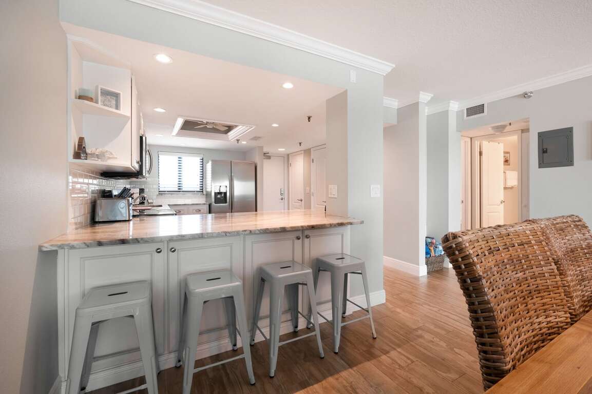 Bar top seating with bar stools overlooking the kitchen. Bar top seating with bar stools overlooking the kitchen.