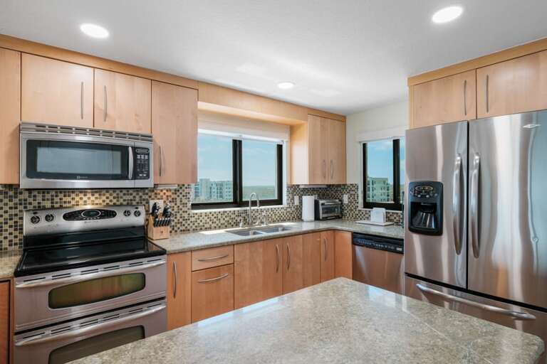 This bright, modern kitchen features a window with a view of the Shorehom by the Sea pool from the sink and views of the Intracoastal and estuary from the west-facing window