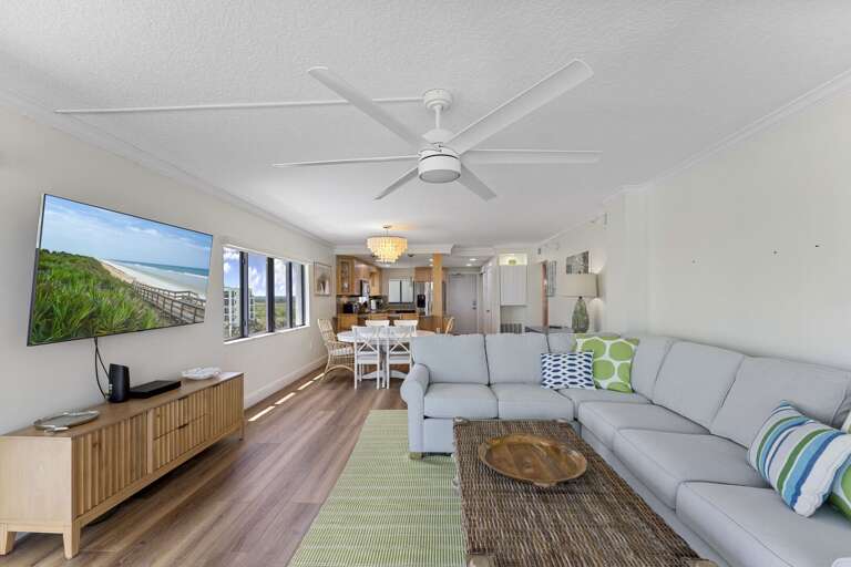 This chic, direct oceanfront living room boasts a large TV, ample sectional seating, and spectacular views of New Smyrna Beach, making it the perfect space to unwind