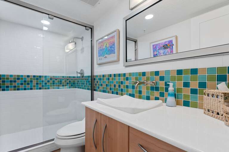The guest bathroom is equipped with a modern glass and tile shower, perfect for relaxing after a day of exploring New Smyrna Beach