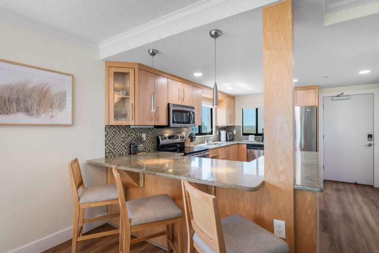 The updated kitchen features modern appliances and bonus barstool seating at the counter for casual dining