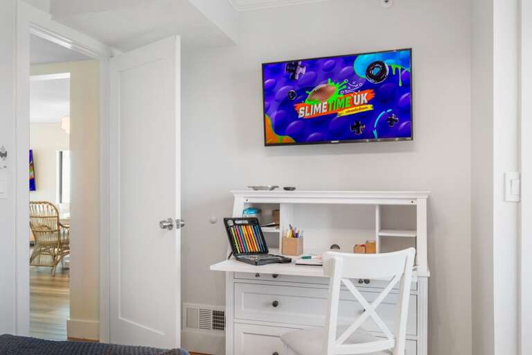 Whether for work or play, the guest bedroom in this New Smyrna Beach condo offers a desk, TV, and a dedicated workspace for all ages