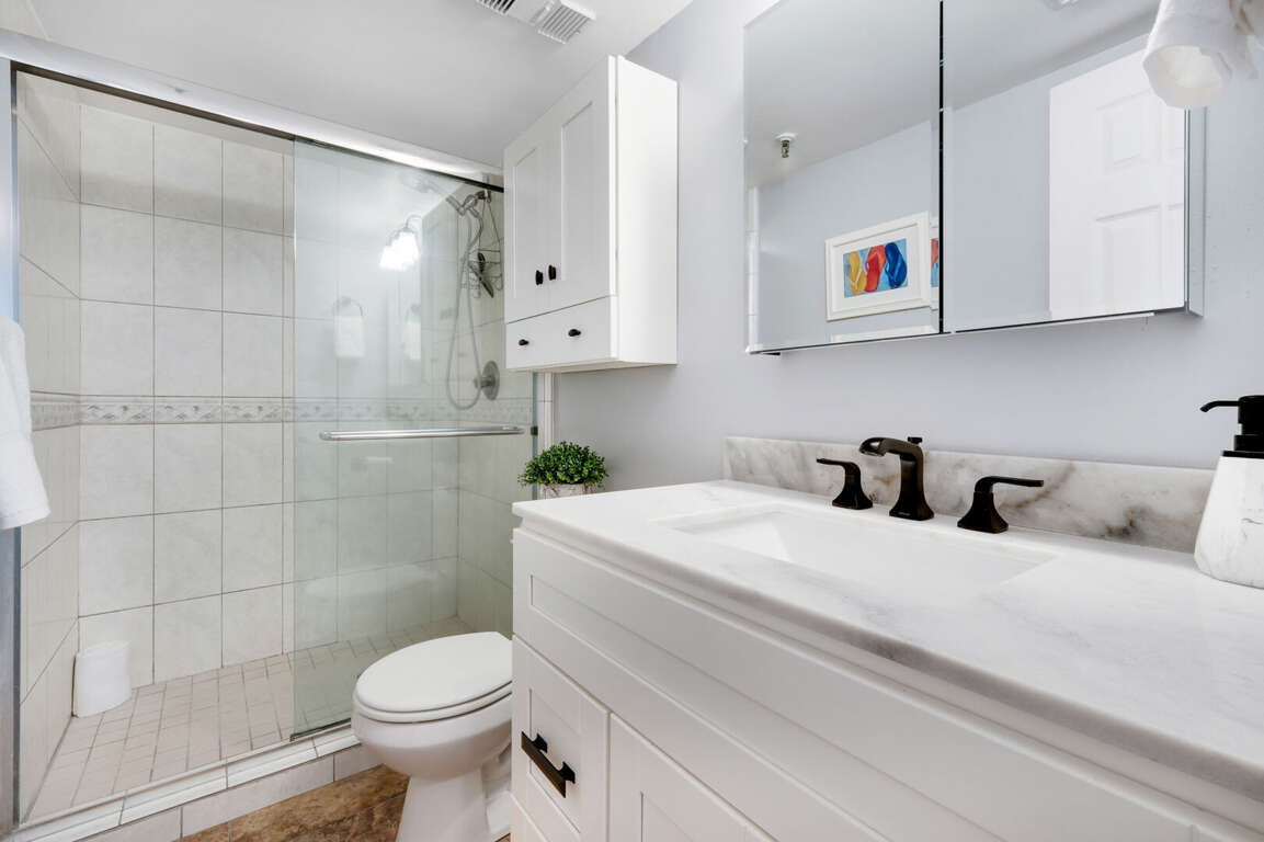 The guest bathroom features a glass and tile shower and plush spa towels The guest bathroom features a glass and tile shower and plush spa towels