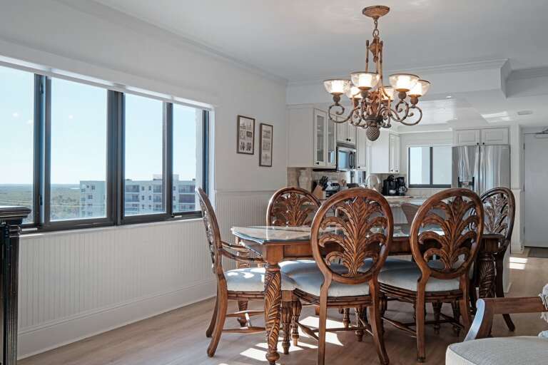 Enjoy seating for six at the dining room table, offering a beautiful view of the ocean and the Shorehom by the Sea pool for a perfect dining experience