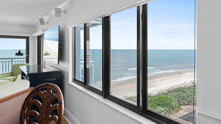 Large corner window in the dining room offers stunning views of New Smyrna Beach and the Shorehom by the Sea pool