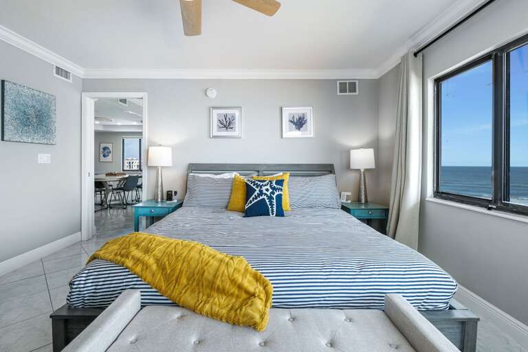 Comfortable master bedroom with a king bed, ocean view, TV, and ensuite bathroom