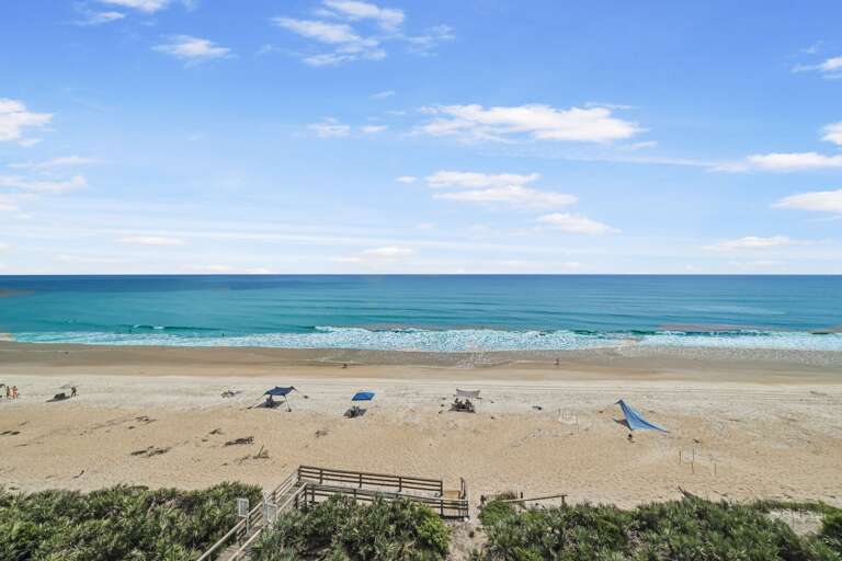 Shorehom by the Sea #65 is a stunning direct oceanfront corner condo on New Smyrna Beach, offering unparalleled views and beachfront access