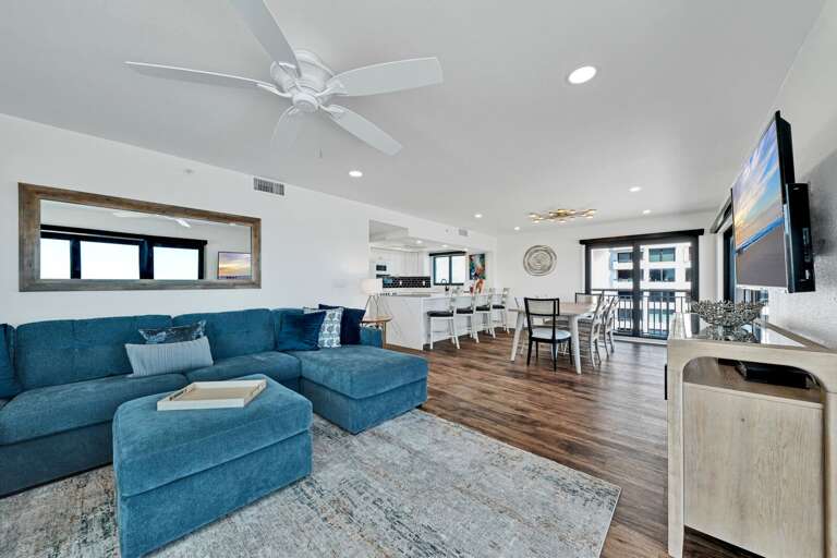 The spacious living room has a comfy sectional and a huge TV