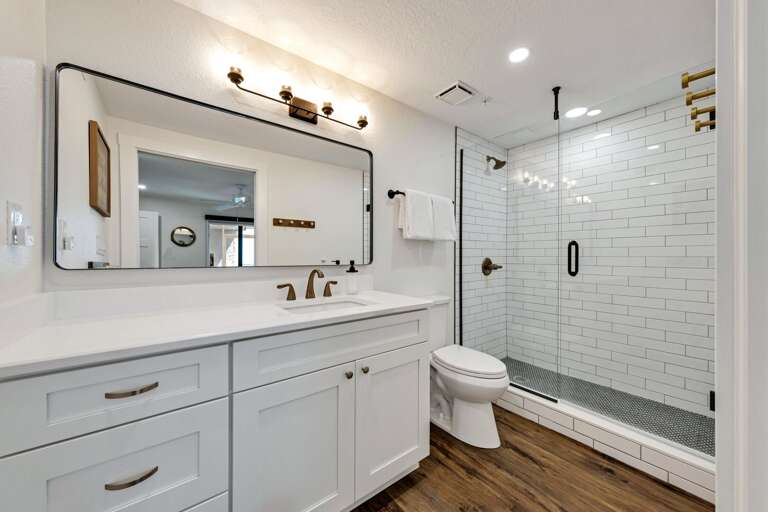 The updated master bathroom provides a spa experience with a gorgeous glass and tile shower and plush, white towels