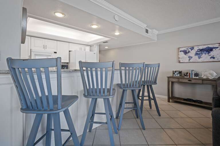 Four additional barstools at the kitchen counter provide extra seating, perfect for enjoying meals or conversation while taking in the ocean views