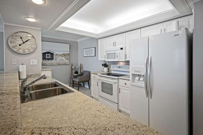 Cook with ease in this fully equipped kitchen, featuring granite countertops and everything you need for your stay in New Smyrna Beach