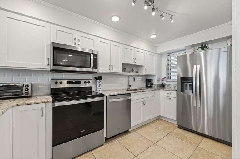 Cook up coastal favorites in the fully equipped kitchen featuring sleek stainless steel appliances. Cook up coastal favorites in the fully equipped kitchen featuring sleek stainless steel appliances.