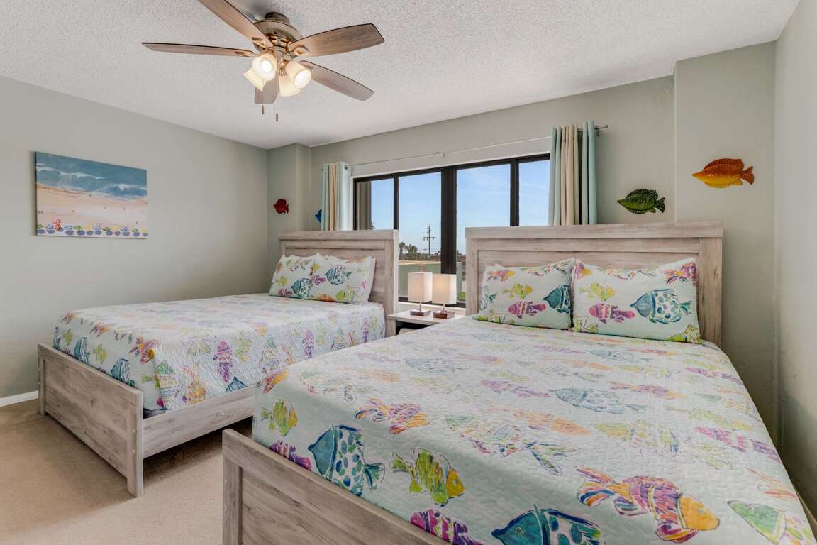 The guest bedroom features two comfortable queen beds and a TV, perfect for families or friends sharing the space The guest bedroom features two comfortable queen beds and a TV, perfect for families or friends sharing the space