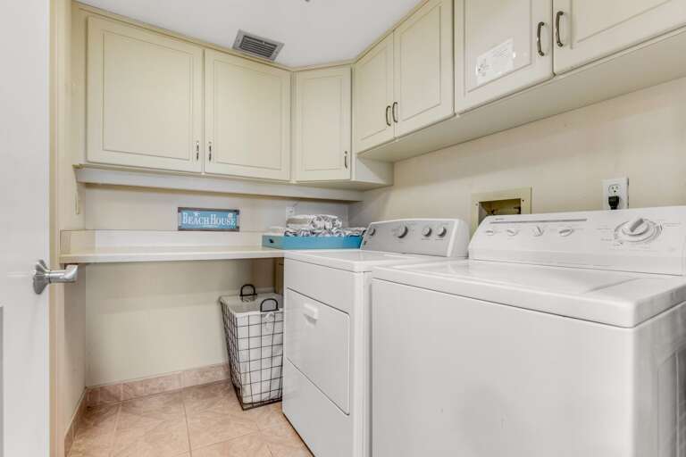 A laundry room with a full-sized washer and dryer is conveniently located inside the condo A laundry room with a full-sized washer and dryer is conveniently located inside the condo