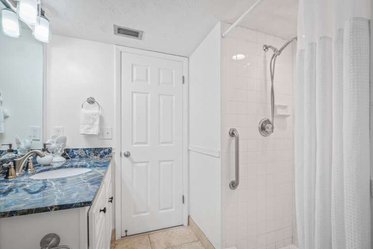 The ensuite northern guest bedroom has an updated tile shower and plush spa towels