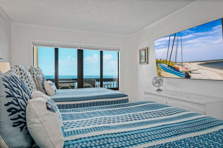 The oceanfront northern guest bedroom accommodates up to 4 guests with two queen beds