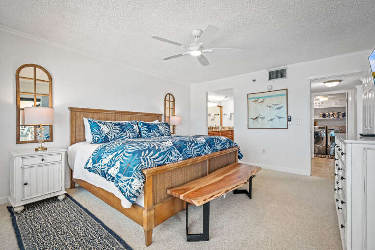 The spacious master bedroom suite has a king bed, large TV, ensuite bathroom, and an ocean view