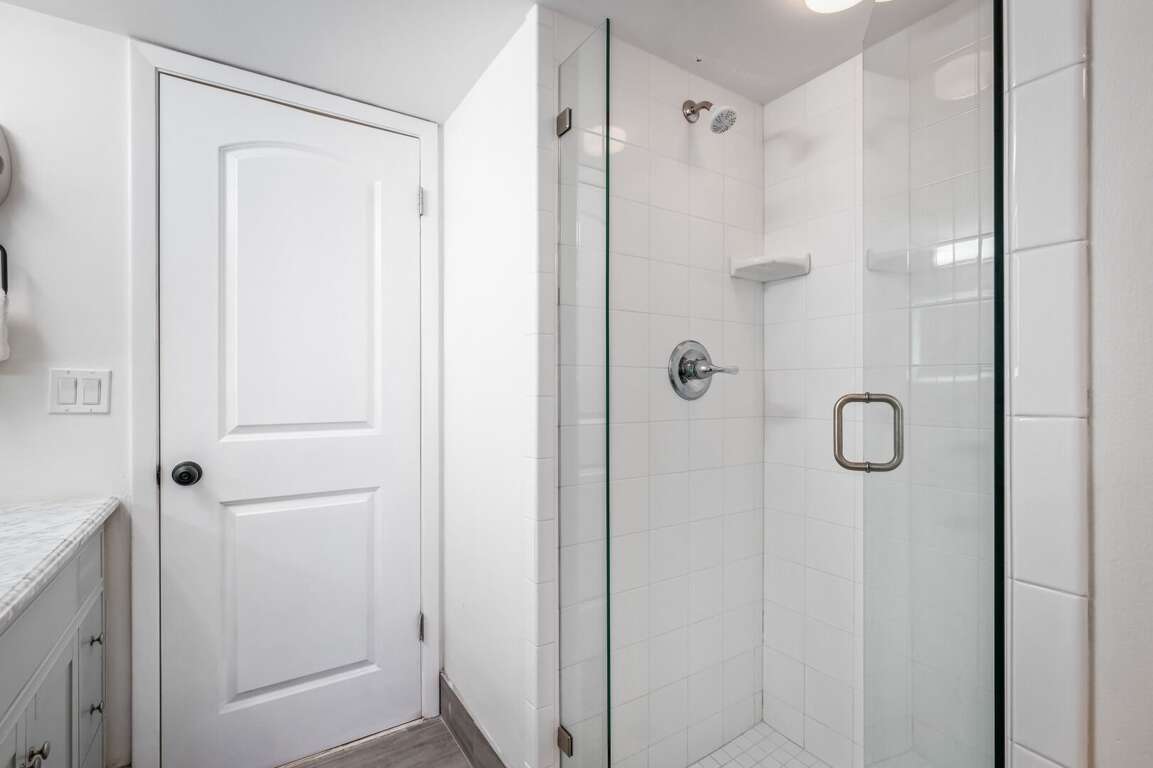 The guest bathroom features a sleek glass and tile shower—offering a clean, modern space to refresh after the beach The guest bathroom features a sleek glass and tile shower—offering a clean, modern space to refresh after the beach