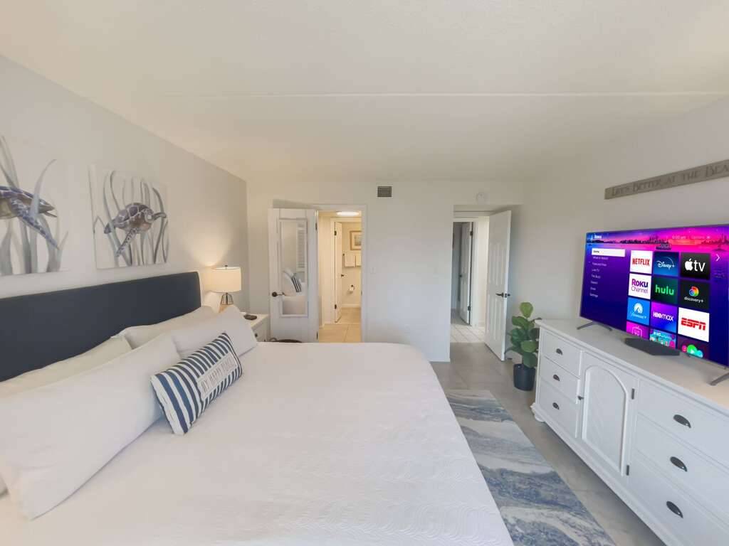 Relax in the master bedroom, featuring a large smart TV and a comfortable king bed, perfect for a restful night's sleep Relax in the master bedroom, featuring a large smart TV and a comfortable king bed, perfect for a restful night's sleep