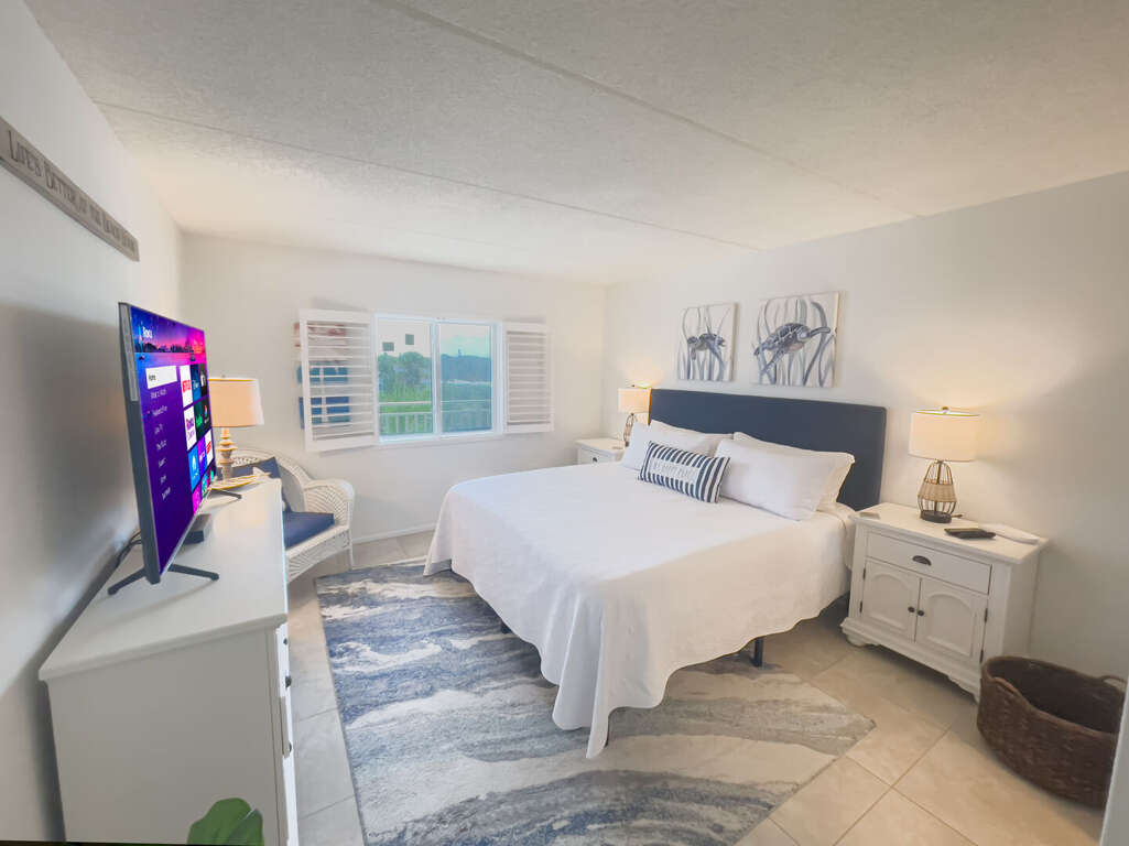 Relax in the master bedroom suite featuring a plush king bed, a flat-screen TV, and a private ensuite bathroom Relax in the master bedroom suite featuring a plush king bed, a flat-screen TV, and a private ensuite bathroom