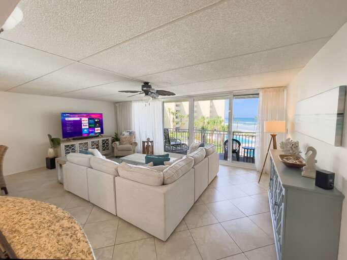 Take in the spacious oceanfront living room, with sliding glass doors that open to stunning views of New Smyrna Beach just outside Take in the spacious oceanfront living room, with sliding glass doors that open to stunning views of New Smyrna Beach just outside