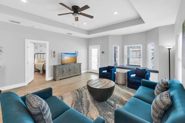 Spacious Living Space With Pale Walls, Plush Blue Sofas, And Wooden Accents