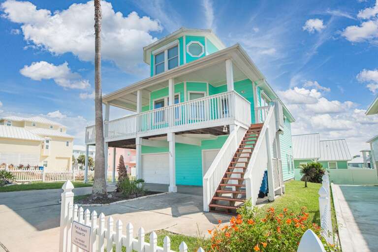 Two-story Beach House With Blue Trim And Stairs
