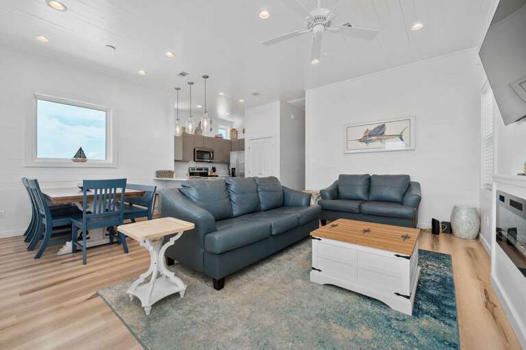 Interior Living Space With Sectional Sofa, Dining Area, And Kitchen