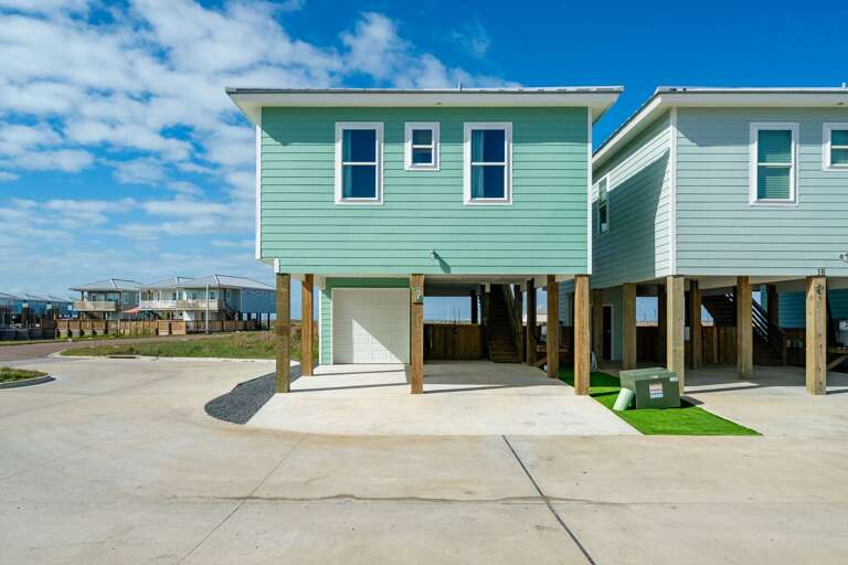 Blue Beach Building On Stilts Under Sunny Skies