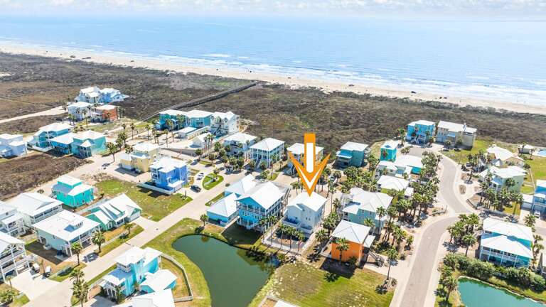 Aerial View Of Seaside Settlement, Azure Roofs And Sandy Shores