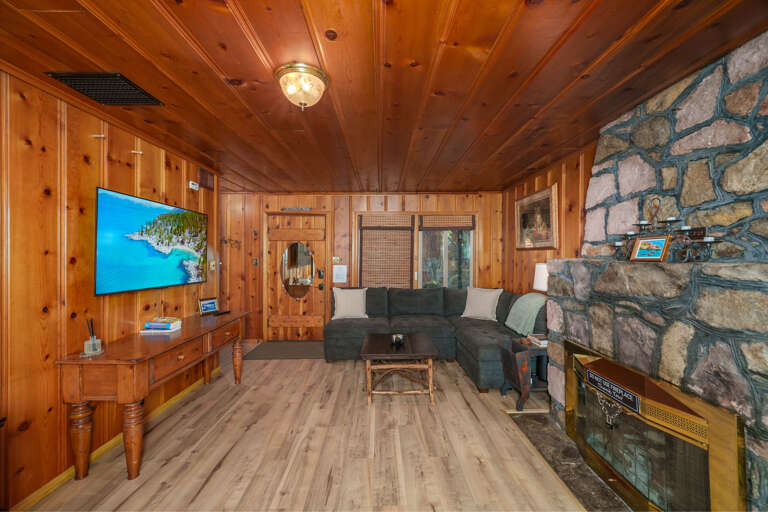 Wood-walled Room With Stone Fireplace And Flat-screen TV