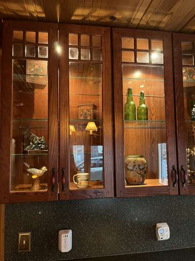 Wooden Cabinet With Glass Doors Displaying Decorative Items And Books