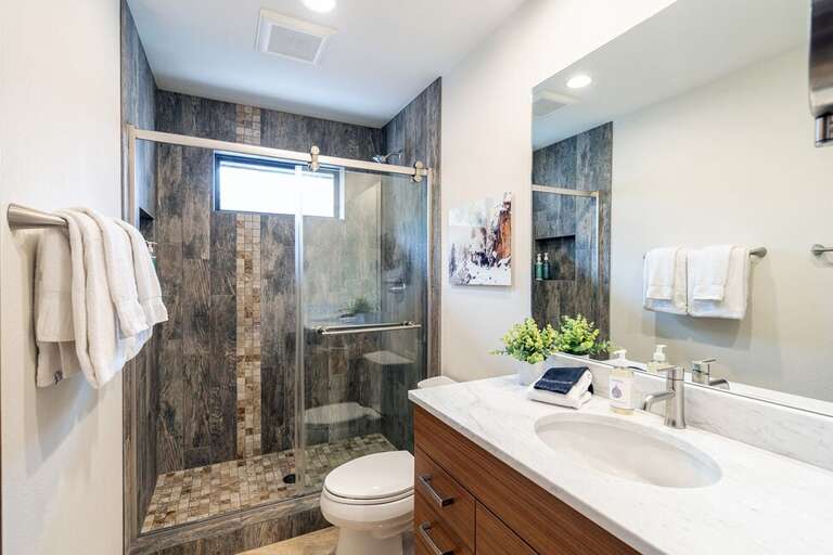 Primary  en suite bathroom includes step-in shower and spacious vanity.