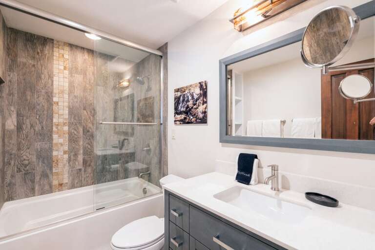 The upstairs shared bathroom features tub/shower combo and single vanity.