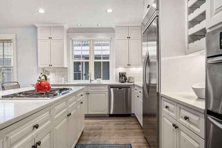 Chefs Kitchen with ample counter space, 4 seat island and stainless appliances with gas stove.